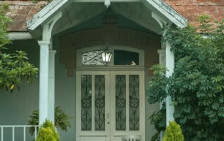 Photo of a house with wood porch columns and a door.